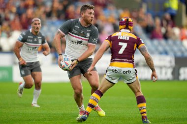 Scott Taylor #30 of Hull FC runs at Theo Fages #7 of Huddersfield Giants 