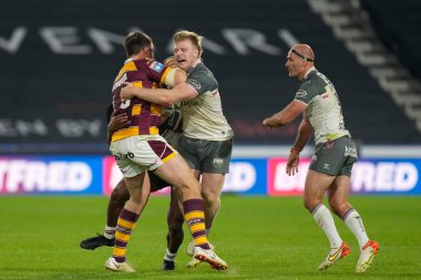 Joe Greenwood #15 of Huddersfield Giants is tackled by Brad Fash #17 of Hull FC 