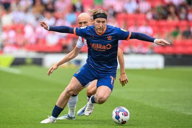 Josh Bowler #11 of Blackpool holds off Will Smallbone #18 of Stoke City