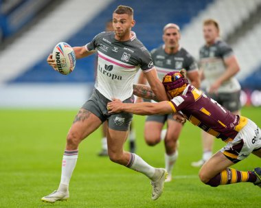 Jack Walker #36 of Hull FC makes a break as Theo Fages #7 of Huddersfield Giants attempts a tackle