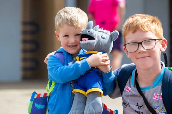 A young Leeds Rhinos supporter holds his Ronnie the Rhino plush teddy ahead of the game 