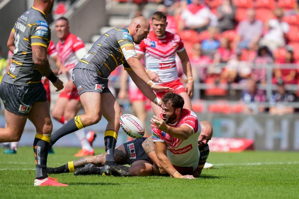 Alex Walmsley #8 of St Helens offloads the ball