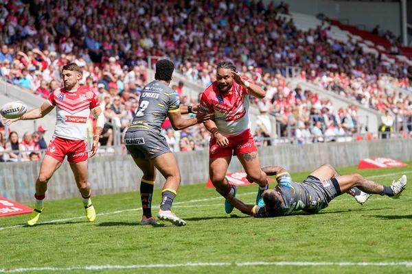 Konrad Hurrell #23 of St Helens looks to offload the ball but Tommy Makinson cannot collect it
