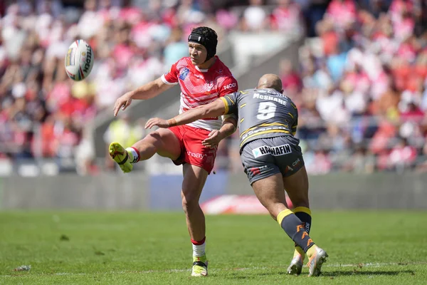 Paul McShane #9 of Castleford Tigers tackles Jonny Lomax #6 of St Helens as he puts up a kick
