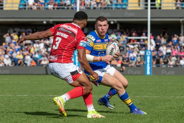Cameron Smith #17 of Leeds Rhinos attempts to get round Kallum Watkins #3 of Salford Red Devils 