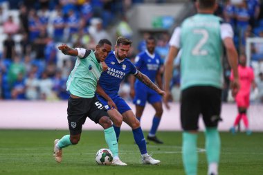 Haji Mnoga #5 of Portsmouth  and Joe Ralls #8 of Cardiff City  compete for the ball