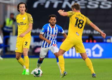 Duane Holmes #19 of Huddersfield Town goes in to tackle Ryan Ledson #18 of Preston North End