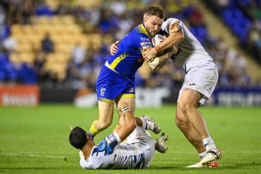 Daryl Clark #9 of Warrington Wolves is tackled by Joe Bretherton #16 of Toulouse Olympique