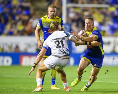 Jason Clark #14 of Warrington Wolves is tackled by Chris Hankinson #21 of Toulouse Olympique