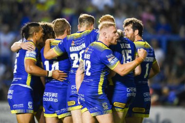 Oliver Holmes #12 of Warrington Wolves celebrates his sides try with team mates