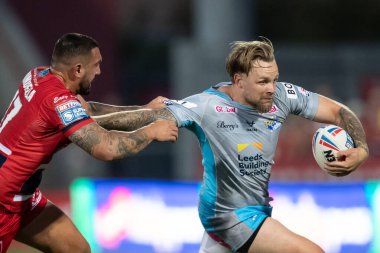 Blake Austin #6 of Leeds Rhinos is tackled by Elliot Minchella #17 of Hull KR during the first half 