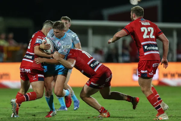 Sam Walters #22 of Leeds Rhinos is tackled by the Hull KR defence