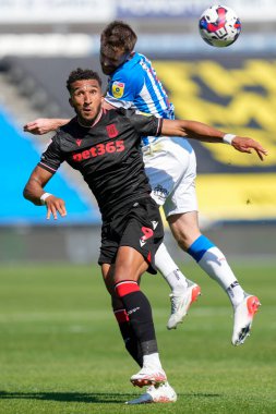 Oliver Turton #2 of Huddersfield Town competes for a header with Jacob Brown #9 of Stoke City 