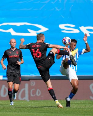 Tino Anjorin #8 of Huddersfield Town competes for the ball with Ben Wilmot #16 of Stoke City 