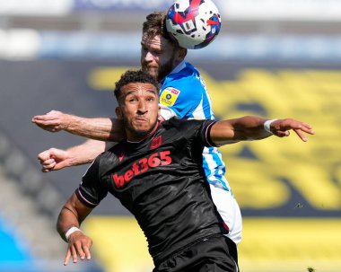 Oliver Turton #2 of Huddersfield Town competes for a header with Jacob Brown #9 of Stoke City 