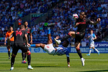 Aden Flint #4 of Stoke City takes the ball full in the face from an overhead kick by Tino Anjorin #8 of Huddersfield Town 