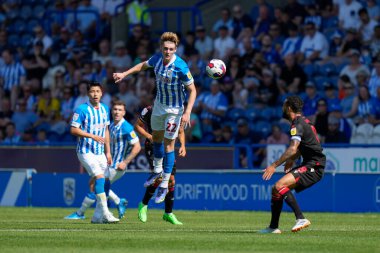Jack Rudoni #22 of Huddersfield Town wins a header 