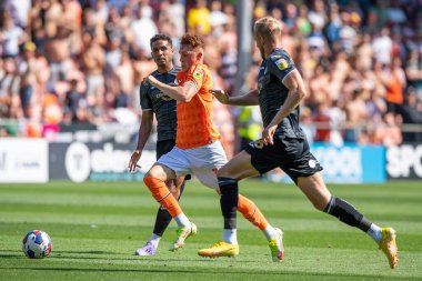 Sonny Carey #16 of Blackpool makes a break with the ball past Harry Darling #6 of Swansea City