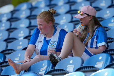 Huddersfield Town fan apply the factor 50 sun block before the match