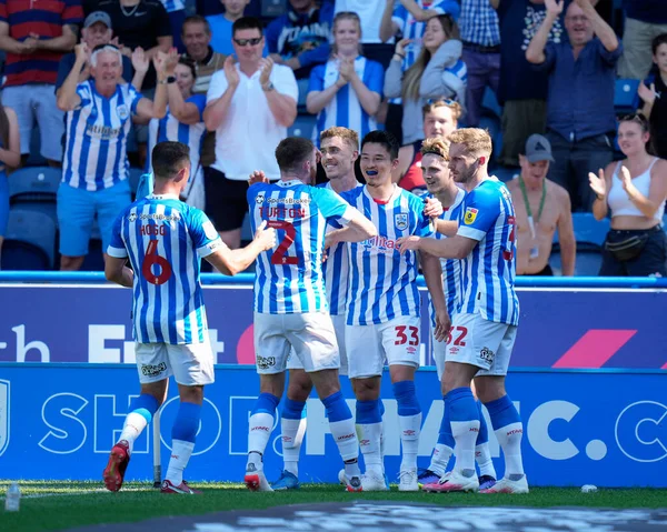 Town players celebrate with Yuta Nakayama #33 of Huddersfield Town after his opening goal