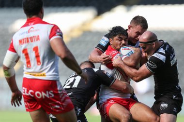 James Bell #20 of St Helens is tackled by the Hull FC defence