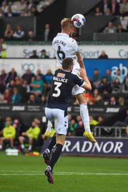 Harry Darling #6 of Swansea City headers at goal Under pressure from Murray Wallace #3 of Millwall 