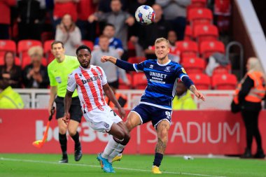 Riley McGree #8 of Middlesbrough clears the ball under pressure from Tariqe Fosu of Stoke City