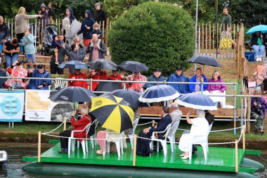 A float arrives carrying event organisers and local councillors as the Chelsea Pensioners salute them. 