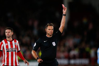 Referee James Linington issues a red card to Dan Neil #24 of Sunderland 