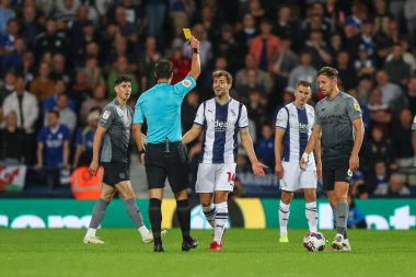 Jayson Molumby #14 of West Bromwich Albion receives a yellow card from referee Andy Madley