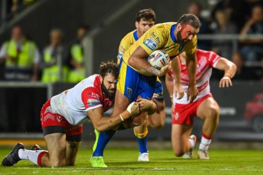 Kane Linnett #12 of Hull KR is tackled by Alex Walmsley #8 of St Helens