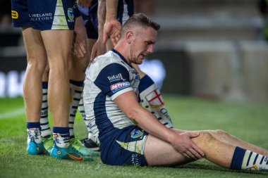 Ben Currie #11 of Warrington Wolves hurts his leg after scoring the try 