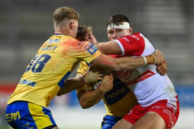 Ben Davies #22 of St Helens is tackled by Mikey Lewis #20 and Connor Barley #38 of Hull KR