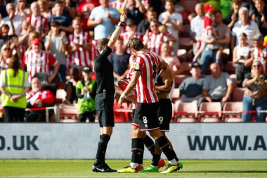 Referee Leigh Doughty issues a yellow card to Iliman Ndiaye #29 of Sheffield United 
