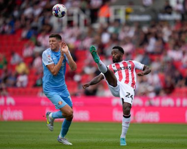 Ross Stewart #14 of Sunderland takes evasive action as Tariquw Fosu #24 of Stoke City clears the ball