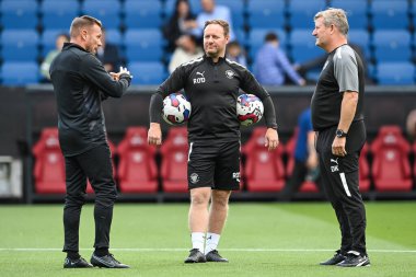 Craig Bellamy Assistant Manager of Burnley chats with David Kerslake and Richard ODonnell Assistant Head Coach of Blackpool during the pre-game warmup 