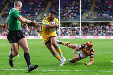 Rhyse Martin #12 of Leeds Rhinos gets past Theo Fages #7 of Huddersfield Giants to score his try