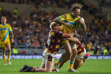 Blake Austin #6 of Leeds Rhinos is tackled by Matty English #14 of Huddersfield Giants 