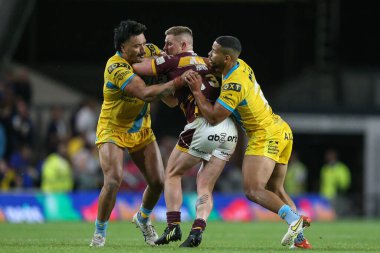 Luke Yates #13 of Huddersfield Giants is tackled by Zane Tetevano #13 and Kruise Leeming #9 of Leeds Rhinos 