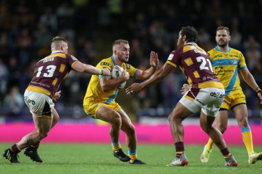Jarrod OConnor #24 of Leeds Rhinos holds off Luke Yates #13 and Leroy Cudjoe #21 of Huddersfield Giants  