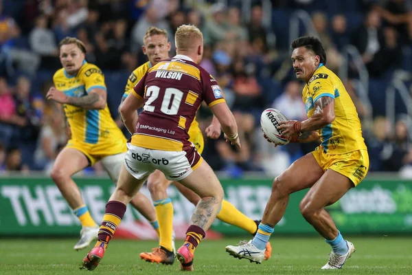 Zane Tetevano #13 of Leeds Rhinos runs at Oliver Wilson #20 of Huddersfield Giants 