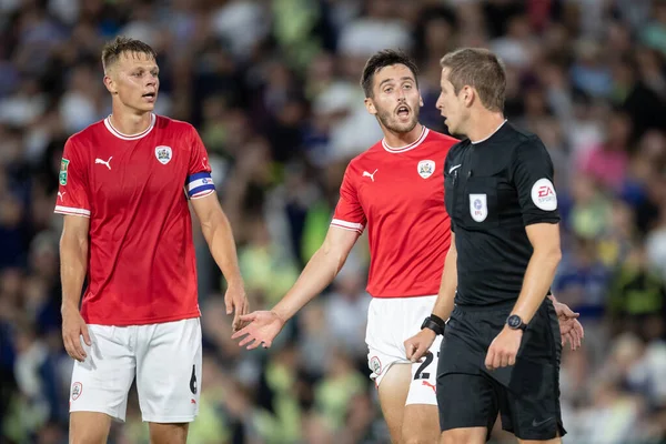 Conor McCarthy #21 and Mads Andersen #6 of Barnsley protest to Referee John Brooks over the penalty awarded to Leeds in the first half 