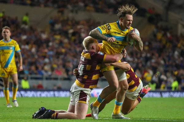 Blake Austin #6 of Leeds Rhinos is tackled by Matty English #14 of Huddersfield Giants 