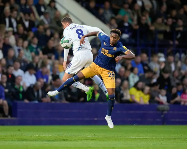 Reece McAlear #8 of Tranmere Rovers competes for a header with Joe Willock #28 of Newcastle United 