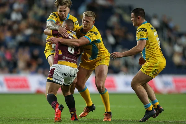 Danny Levi #9 of Huddersfield Giants is stopped by the Leeds defence
