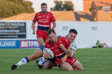 Matt Parcell #9 of Hull KR is tackled by Yusuf Aydin #22 of Wakefield Trinity 