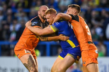 Joe Bullock #15 of Warrington Wolves is tackled by Nathan Massey #14 and Alex Mellor #37 of Castleford Tigers