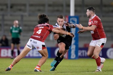 Jordan Lane #13 of Hull FC is tackled by Tim Lafai #4 of Salford Red Devils