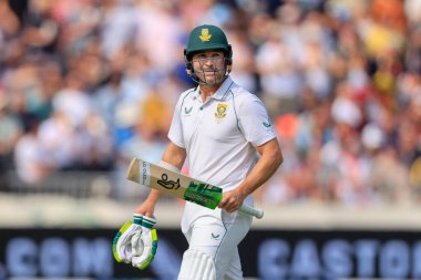 Dean Elgar of South Africa walks back to the pavilion as he is clean bowled by James Anderson of England for 11 runs