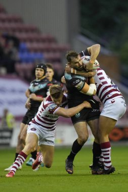 Liam Byrne #20 of Wigan Warriors tackles Alex Walmsley #8 of St Helens
